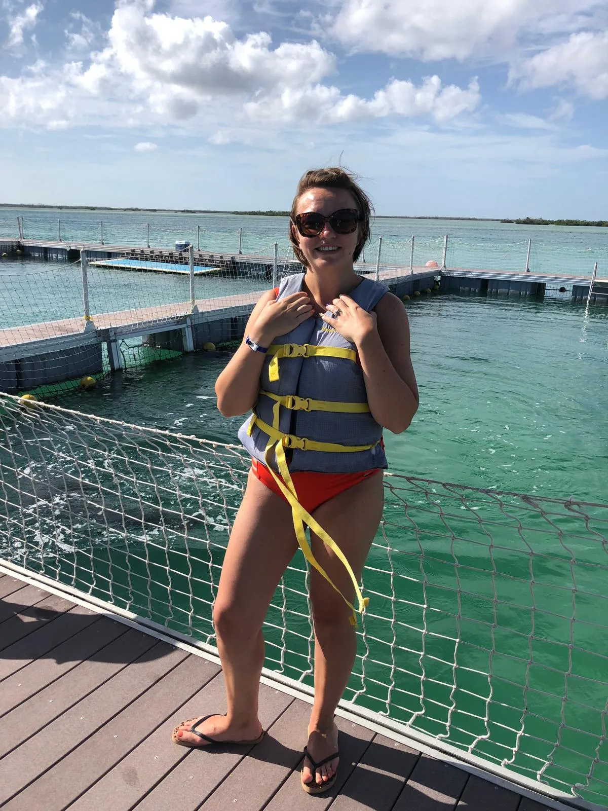 Sam in a life jacket on a pontoon over green water in the Caribbean