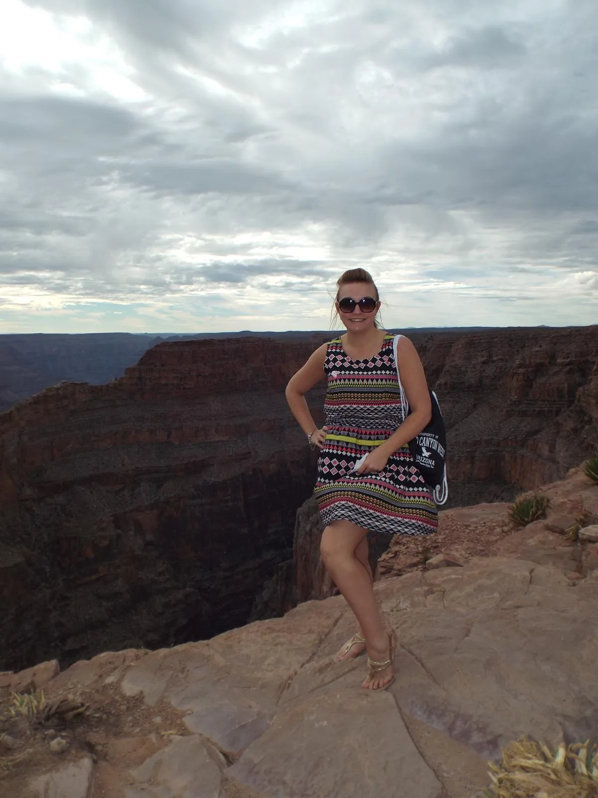 Sam standing on the rim of the Grand Canyon under a cloudy sky