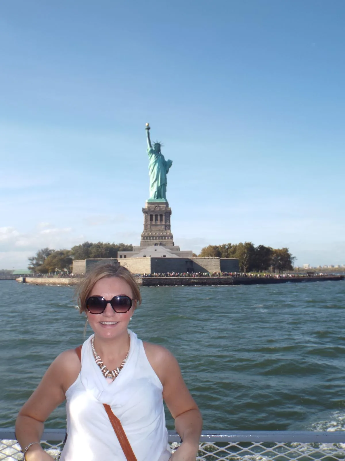 Sam on a boat in New York harbour with the Statue of Liberty behind her